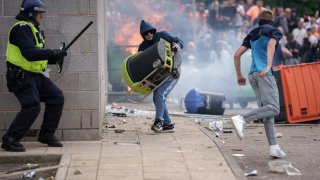 Riot police officers push back anti-migration protesters outside the Holiday Inn Express Hotel which is housing asylum seekers on August 4, 2024 in Rotherham, United Kingdom.