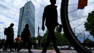 People cross a street in front the headquarters building of the European Central Bank (ECB) in Frankfurt am Main, western Germany, on June 5, 2024.