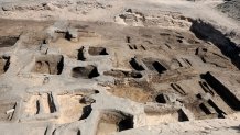 In this image provided by Egypt's Supreme Council of Antiquities, archeologists observe the site where they discovered 63 mud-brick tombs at the Tell al-Deir necropolis, in the Nile Delta town of Damietta, about 125 miles (200 km) north of Cairo, Egypt. The Egyptian Ministry of Tourism and Antiquities announced the discovery of the trove, which includes gold pieces, bronze coins and amulets on July 25, 2024. ( Egypt's Supreme Council of Antiquities via AP)