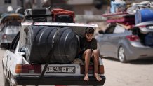 A Palestinian child rides in the trunk of a car as he evacuates Maghazi refugee camp in the central Gaza Strip, as part of a mass evacuation ordered by the Israeli military ahead of an operation, Saturday, Aug. 17, 2024.