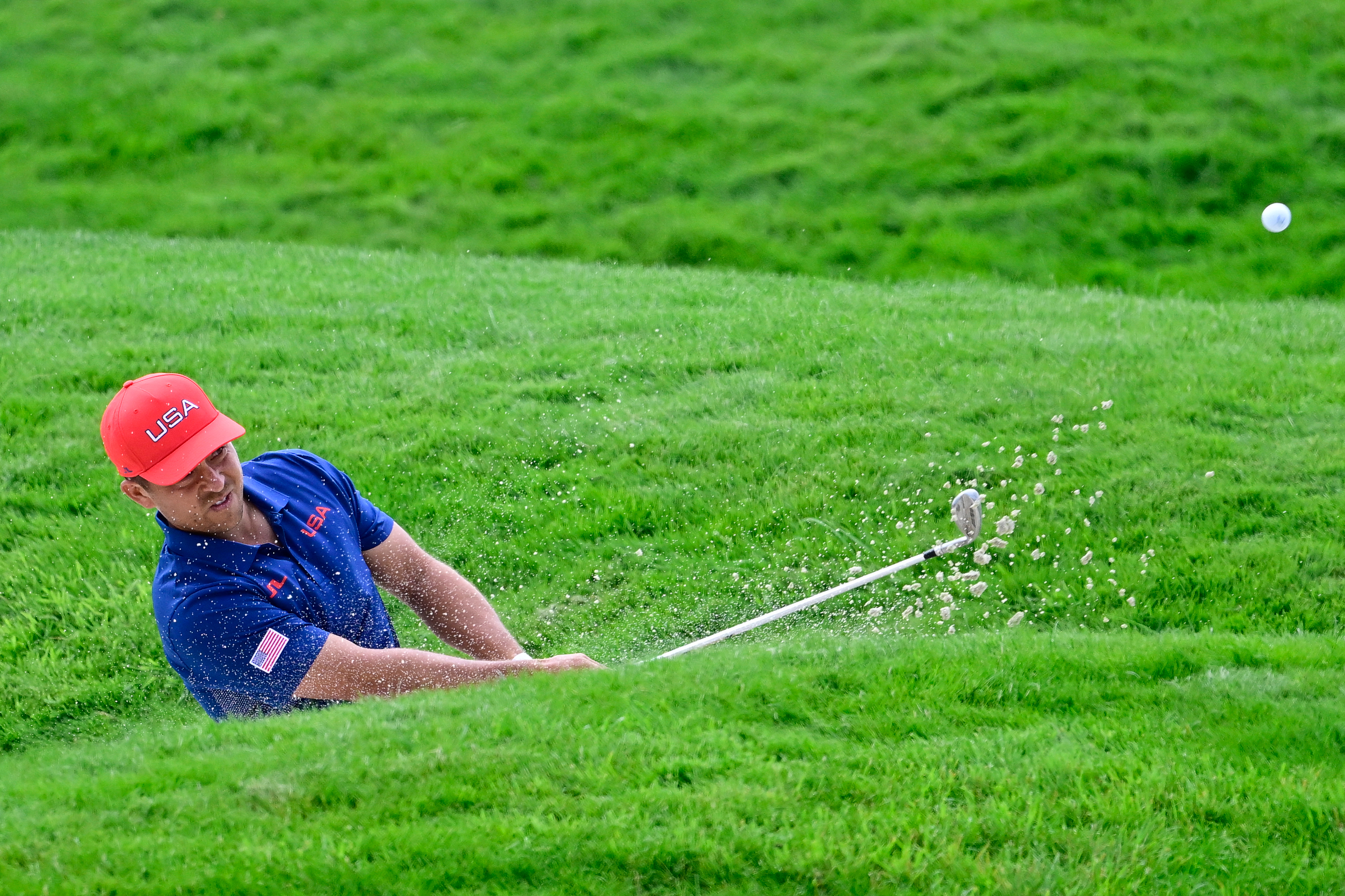 Xander Schauffele takes a shot out of a bunker