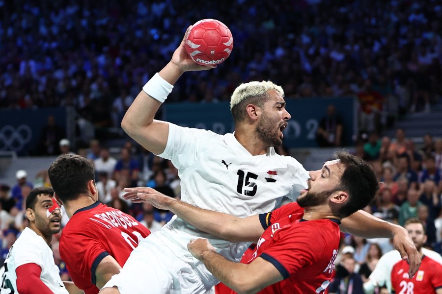 Egypt's left back #15 Ahmed Hesham shoots past Spain's centre back #36 Ian Tarrafeta (R) during the men's quarter-final handball match between Spain and Egypt of the Paris 2024 Olympic Games, at the Pierre-Mauroy stadium in Villeneuve-d'Ascq, northern France, on August 7, 2024