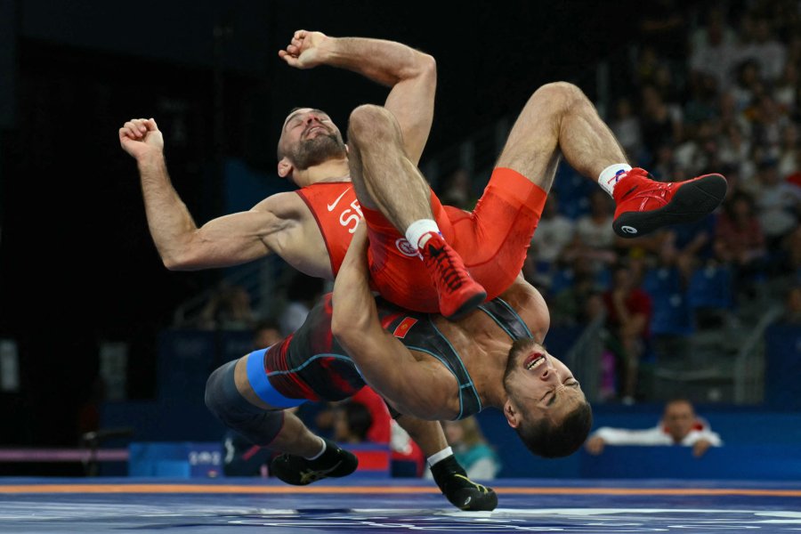 Serbia's Mate Nemes wrestles Kyrgyzstan's Amantur Ismailov (blue) in their men's greco-roman 67kg wrestling repechage match at the Champ-de-Mars Arena during the Paris 2024 Olympic Games, in Paris on August 8, 2024