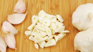 all, chopped and slices of garlic on a wooden cutting board