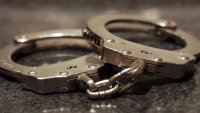 A close up shot of a pair of handcuffs on a table.