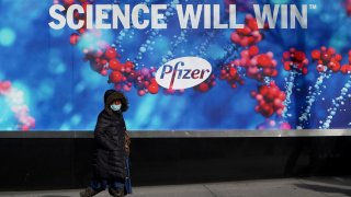 A person walks past the Pfizer Headquarters building in New York, December 7, 2020.