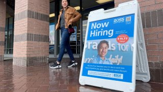 A customer walks by a now hiring sign posted in front of a Ross Dress For Less store on April 07, 2023 in Novato, California.