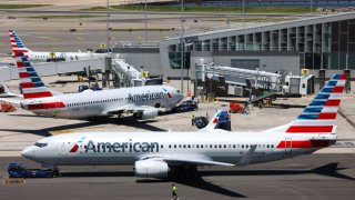 An American Airlines’ Embraer E175LR (front), an American Airlines’ Boeing 737 (C) and an American Airlines’ Boeing 737 are seen parked at LaGuardia Airport in Queens, New York on May 24, 2024. 