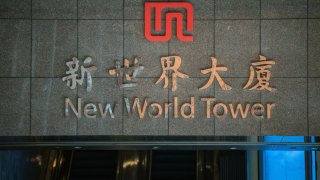 Signage at the New World Tower, which houses the headquarters of New World Development Co., in Hong Kong, China, on Thursday, Sept. 26, 2024. New World Developmen suspended trading of its shares in Hong Kong on Thursday morning.