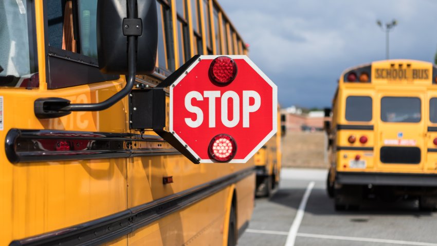 File. School bus driver checking multiple aspects of the bus before route.