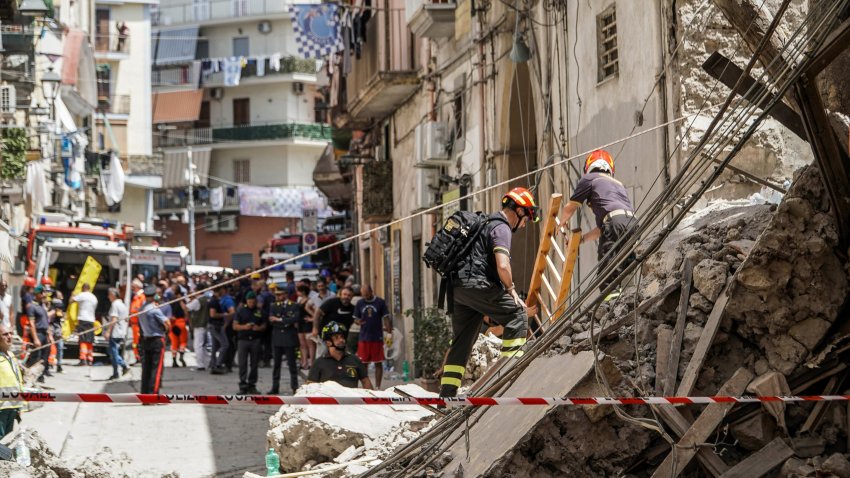 Rescue teams work at the site of a collapsed building