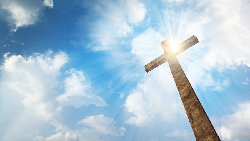 A wooden cross in a sunny sky