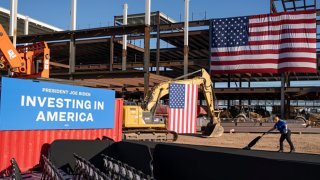 A woman vacuums the stage walkway prior to a speech from President Joe Biden at Intel Ocotillo Campus on March 20, 2024 in Chandler, Arizona.