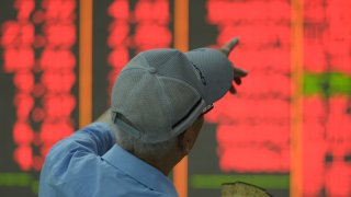 A customer watches stock market at a stock exchange in Hangzhou, China, on September 27, 2024. 