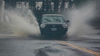 Vehicles move through a partially flooded street in Dunedin ahead of Hurricane Milton’s expected landfall tonight on October 9, 2024 in Florida.