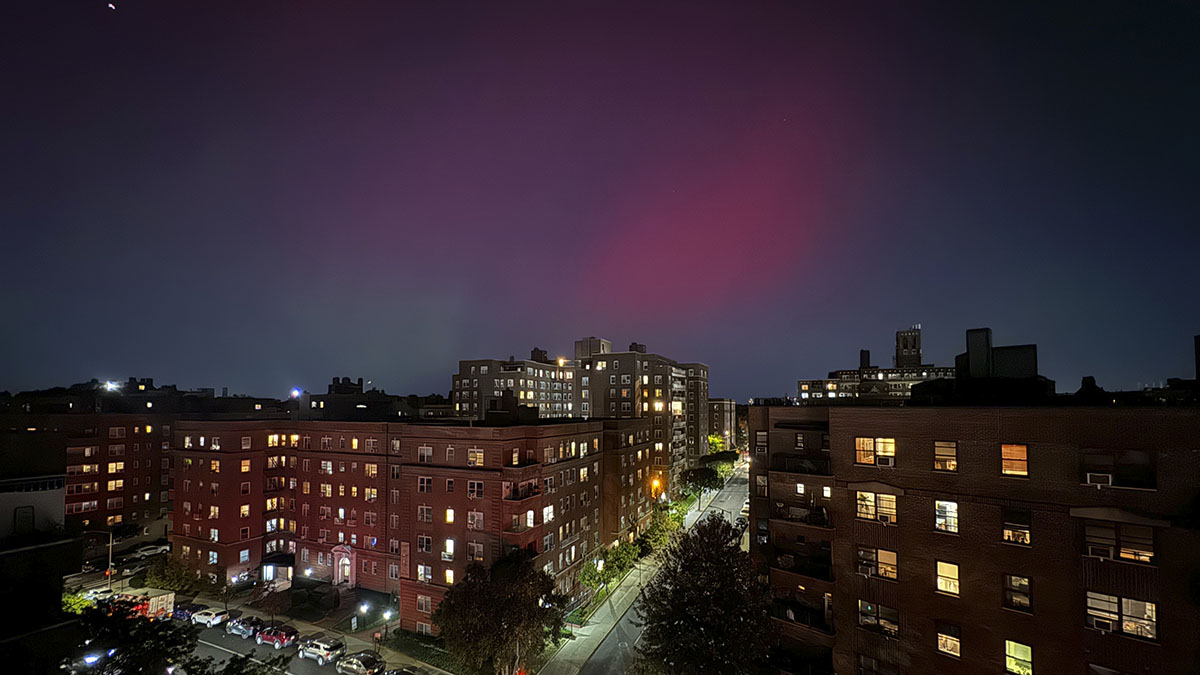 The Northern lights glow in the night sky above apartment buildings in the Queens borough of New York, Thursday, Oct. 10, 2024. (AP Photo/Daniel P. Derella)