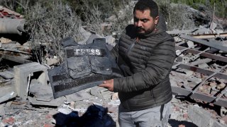 A journalist carries the flack jacket, at the site where an Israeli airstrike hit a compound housing journalists, killing three media staffers from two different news agencies according to Lebanon’s state-run National News Agency, in Hasbaya village, southeast Lebanon, Friday, Oct. 25, 2024.