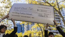 A giant cheque for the prize money is held aloft at the Timothee Chalamet lookalike contest near Washington Square Park, Sunday, Oct. 27, 2024, in New York. (AP Photo/Stefan Jeremiah)