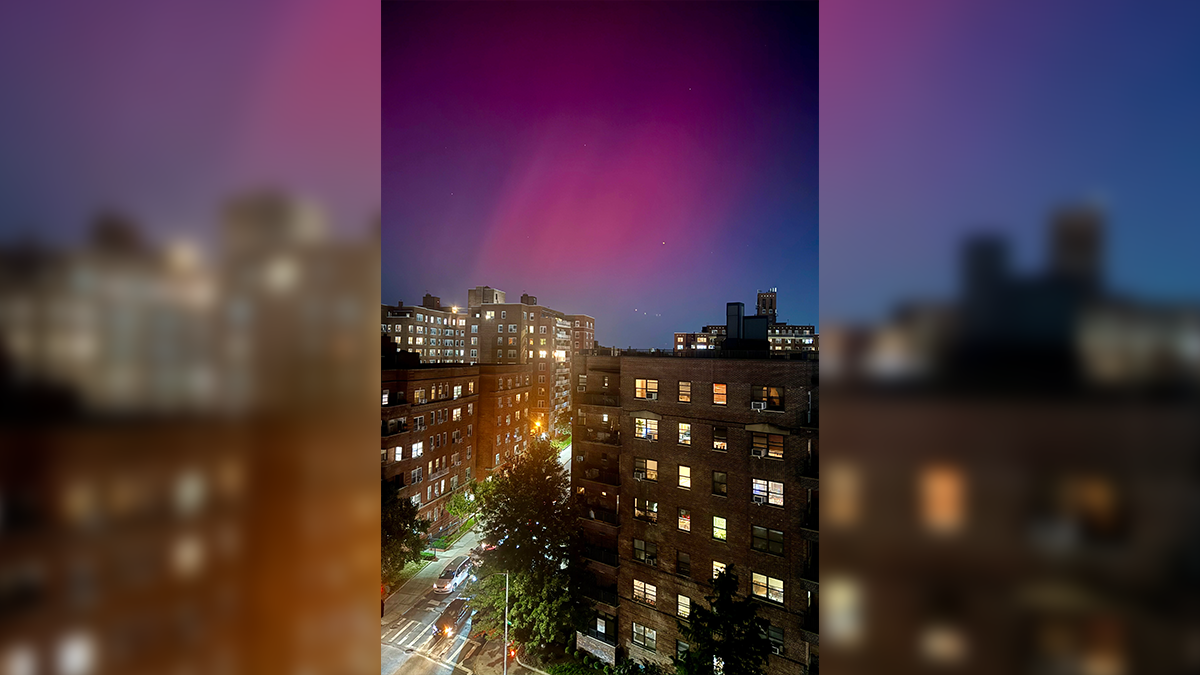 The Northern lights glow in the night sky above apartment buildings in the Queens borough of New York, Thursday, Oct. 10, 2024. (AP Photo/Daniel P. Derella)