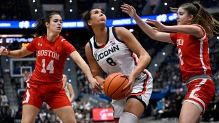 UConn center Jana El Alfy (8) looks to shoot between Boston University guard Ines Monteagudo Pardo (14) and Boston University forward Allison Schwertner in the first half of an NCAA college basketball game, Thursday, Nov. 7, 2024, in Hartford, Conn.