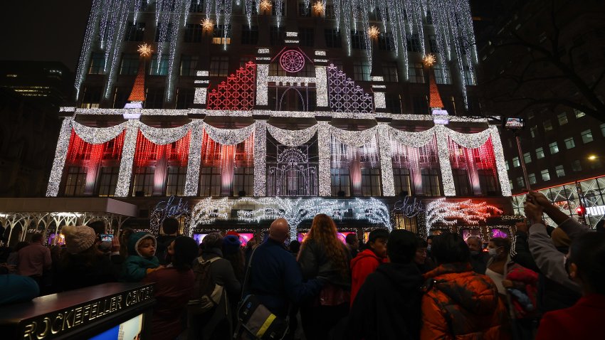 NEW YORK, NY – DECEMBER 18: Crowd gather at Rockefeller center to see light show on Saks Fifth Avenue store building decorated with Christmas lights in New York City, United States on December 18, 2021. (Photo by Tayfun Coskun/Anadolu Agency via Getty Images)