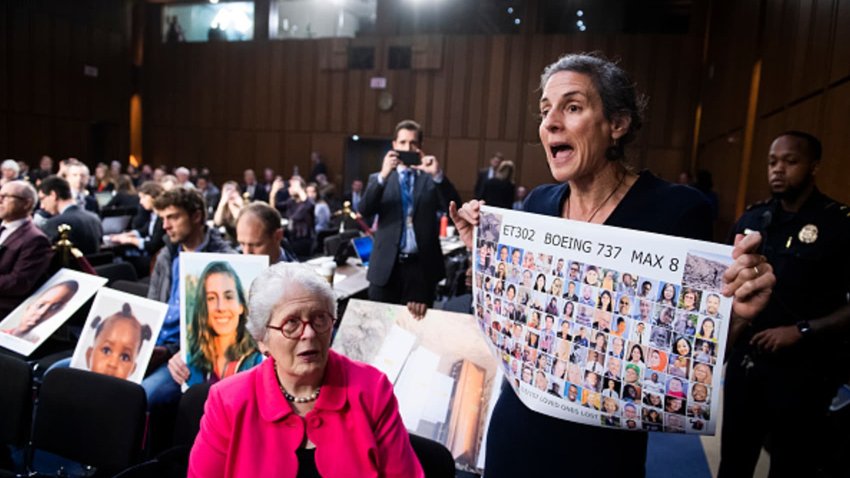 Nadia Milleron, whose daughter Samya Stumo, was killed in the crash of Ethiopian Airlines Flight 302, holds a sign of crash victims behind Dennis Muilenburg, foreground, CEO of Boeing, during the Senate Commerce, Science and Transportation Committee hearing in Hart Building on aviation safety and the future of the Boeing 737 MAX on Tuesday, October 29, 2019. 