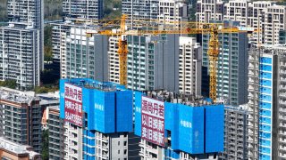 A large advertisement touting China’s “trade-in” policy hangs outside a housing construction project in Nanjing, China, on Nov. 29, 2024.