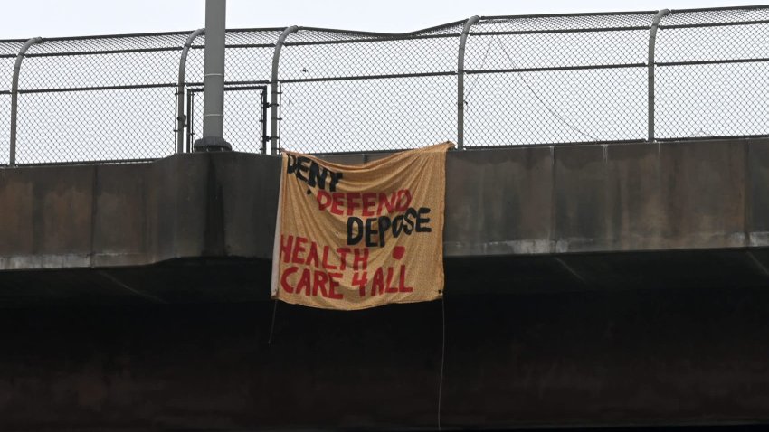 A banner hanging from on overpass along the southbound lane of I-83 that says, “Deny Defend Depose Health Care 4 All.”