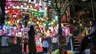 People look at homes decorated with Christmas lights and ornaments in Dyker Heights neighborhood, Brooklyn, New York City on December 20, 2023. 