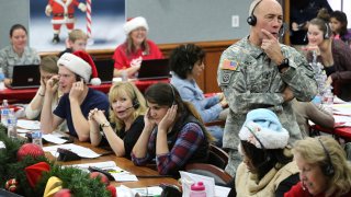 FILE – NORAD Chief of Staff Maj. Gen. Charles D. Luckey takes a call while volunteering at the NORAD Tracks Santa center at Peterson Air Force Base in Colorado Springs, Colo., Dec. 24, 2014.