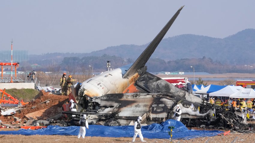 Firefighters and rescue team members work near the wreckage of a passenger plane at Muan International Airport