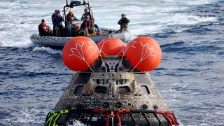 FILE - NASA's Orion capsule is drawn to the well deck of the USS Portland after it splashed down following a successful uncrewed Artemis I moon mission, in the Pacific Ocean off the coast of Baja California, Mexico, Dec. 11, 2022.