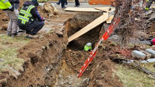 Firefighters rescued a worker who was trapped thigh-high in a trench and suffering from hypothermia in Stamford on Friday morning.