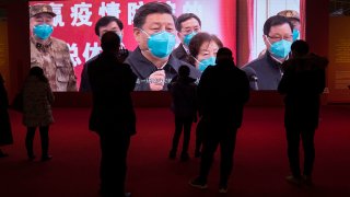 FILE - People attend an exhibition on the city's fight against the coronavirus in Wuhan in central China's Hubei province, Jan. 23, 2021.