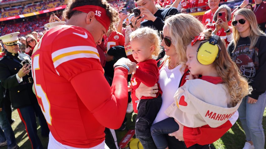 KANSAS CITY, MISSOURI – NOVEMBER 10: Patrick Mahomes #15 of the Kansas City Chiefs fist bumps his son, Bronze, while his wife and daughter, Brittany and Sterling, watch prior to a game against the Denver Broncos at GEHA Field at Arrowhead Stadium on November 10, 2024 in Kansas City, Missouri.