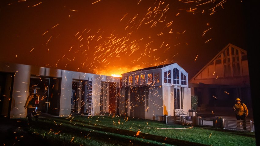 LOS ANGELES, CALIFORNIA – JANUARY 8: A Firefighter watches the flames from the Palisades Fire burning in front of the Pacific Palisades Presbyterian Church during a powerful windstorm on January 8, 2025 in the Pacific Palisades neighborhood of Los Angeles, California. The fast-moving wildfire is threatening homes in the coastal neighborhood amid intense Santa Ana Winds and dry conditions in Southern California. (Photo by Apu Gomes/Getty Images)