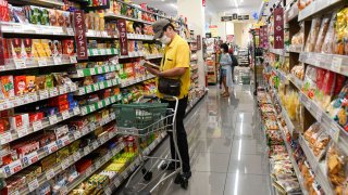 A customer picks up a snack at a supermarket store in Tokyo, Japan, on Tuesday, July 27, 2021.