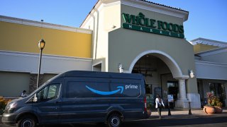 An Amazon Prime delivery van sits parked outside of a Whole Foods Market grocery store on August 26, 2024 in El Segundo, California.