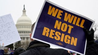 A person displays a sign as labor union activists rally in support of federal workers during a protest, with the U.S. Capitol in the background on Capitol Hill in Washington, U.S., Feb. 11, 2025.