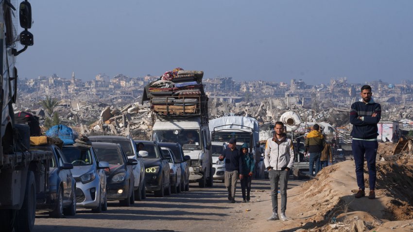 Displaced Palestinians, traveling in vehicles, wait to cross through a security checkpoint at the Netzarim corridor as they make their way from central Gaza to the northern Gaza Strip, Tuesday, Feb. 18, 2025.