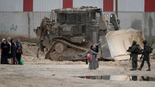 Israeli soldiers check the identification cards of Palestinians while they evacuate their homes in the West Bank refugee camp of Nur Shams, near Tulkarem, while the Israeli military operation continues in the area on Tuesday, Feb. 11, 2025.