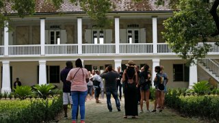 FILE - Visitors walk outside the main plantation house
