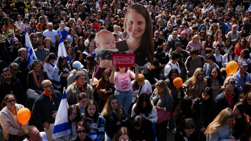 People watch a live broadcast from the funeral of slain hostages Shiri Bibas and her two children, Ariel and Kfir, at a plaza known as the Hostages Square in Tel Aviv, Israel, Wednesday, Feb. 26, 2025. The mother and her two children were abducted by Hamas on Oct. 7, 2023, and their remains were returned from Gaza to Israel last week as part of a ceasefire agreement with Hamas.