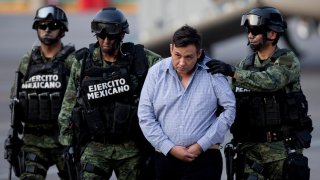 Soldiers escort a man who authorities identified as Omar Trevino Morales, alias “Z-42,” leader of the Zetas drug cartel, as he is moved from a military plane to a military vehicle at the Attorney General’s Office hangar in Mexico City, March 4, 2015.