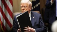 U.S. President Donald Trump holds paperwork he signed during an Ambassador Meeting in the Cabinet Room of the White House in Washington, D.C., on March 25, 2025.