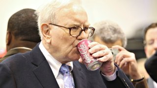 Warren Buffett, chief executive officer of Berkshire Hathaway, drinks a Cherry Coca-Cola as he tours the exhibition floor prior to the Berkshire Hathaway annual meeting in Omaha, Nebraska, on Saturday, May 1, 2010.