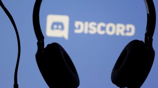Headphones are seen in front of the Discord app logo in this illustration taken March 29, 2021.