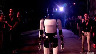 Tesla’s Optimus robots walk on the day of an unveiling event in Los Angeles, California, U.S. October 10, 2024, in this still image taken from a video.