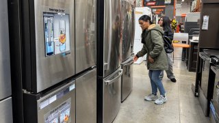 Customers inspect refrigerators displayed at a Home Depot store on March 31, 2025 in San Rafael, California.
