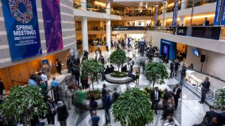 Guests and attendeess mingle and walk through the atrium during the IMF/World Bank Group Spring Meetings at the IMF headquarters in Washington, DC, on April 24, 2025.